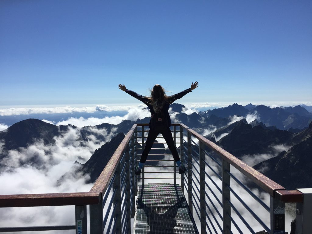 Cô gái bật nhảy trên chiếc cầu hướng về đỉnh núi và nhứng đám mây
